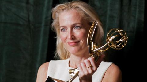 Gillian Anderson holding an Emmy award