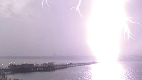 A huge lightning strike at the end of Southend Pier at night.