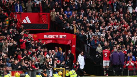 Harry Maguire of Manchester United is applauded by fans after he is substituted