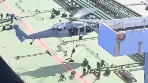 US forces boarding ship in Indian Ocean. Picture shows military member lowering onto the ship on a rope from a helicopter
