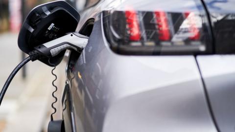 Electric vehicle plugged in to a charging point