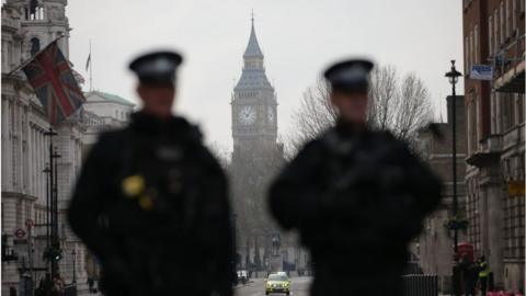 Armed police officers secure the area near the Houses of Parliament