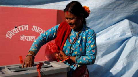 A woman smiles as she cast her vote during parliamentary and provincial elections in Sindhupalchok district, Nepal on 26 November 2017