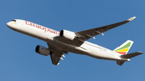 Ethiopian airline flight in mid-air with blue sky background