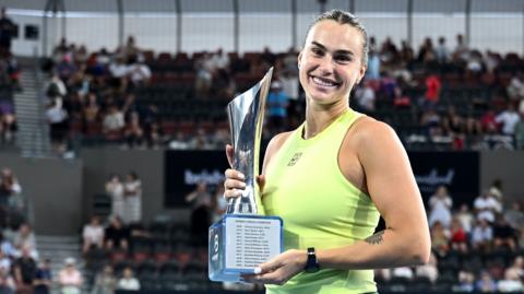 Aryna Sabalenka holds the trophy after winning the Brisbane International