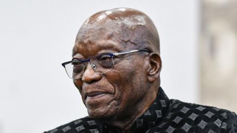 Zuma is pictured wearing glasses and a patterned shirt