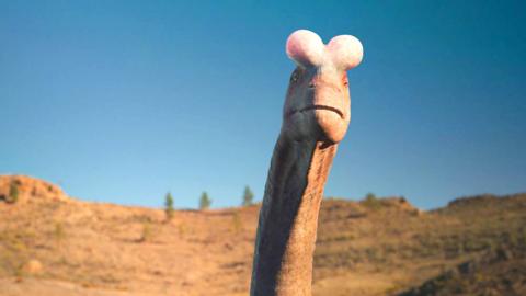 A dinosaur’s neck and head with two large pinkish bulges on its head between its eyes.