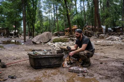 Man sifts through muddied objects