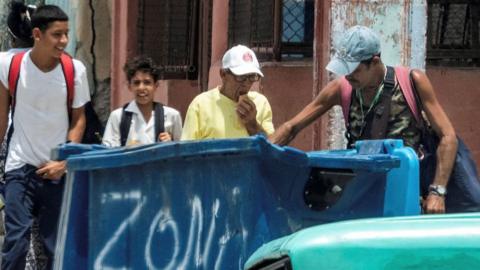 A man rummages through a dumpster in Havana, Cuba on 15 July 2025. 