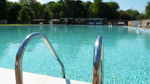 A swimming pool with a metal ladder leading into the water.