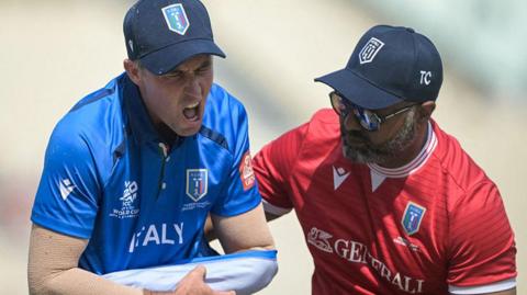 Wayne Madsen is helped from the field by a member of the Italy medical team after he dislocated his shoulder against Scotland