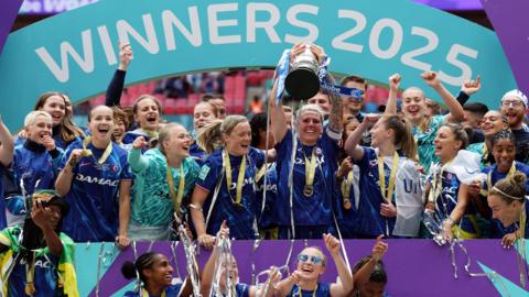 Millie Bright lifting the FA Cup trophy.
