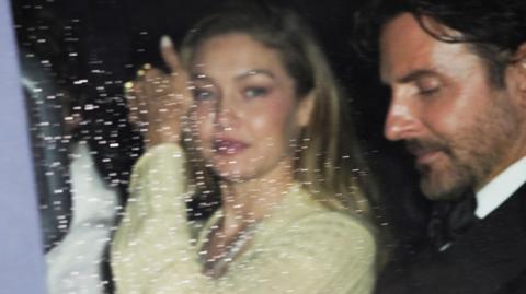 Gigi Hadid and Bradley Cooper leaving, photographed through a car window