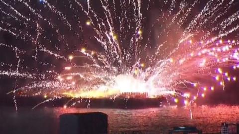 Flames from explosion on boat as fireworks erupt