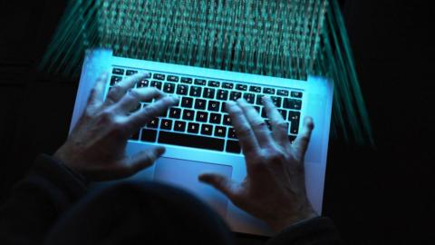 Hands typing on a laptop keyboard