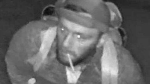 CCTV image of Tyler Reilly wearing a cap the wrong way around, carrying a backpack and has a cigarette in his mouth