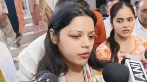 Himanshi Narwal is talking to media persons. Her hair is open and she is wearing an mustard kurta with a printed dupatta. 