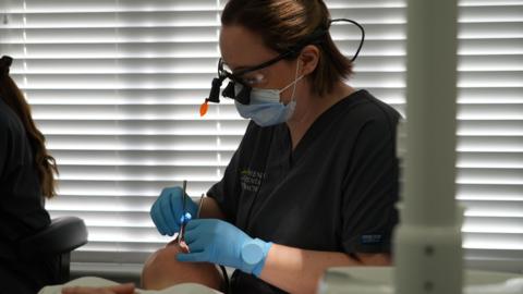 Dr Alba Torrado-Varela is checking someone's teeth.