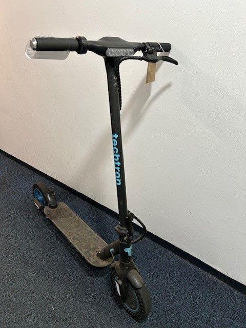 An e-scooter in a hallway, placed against a wall