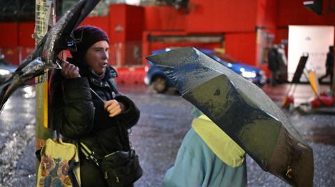 People on the streets of Edinburgh carrying umbrellas as bad weather hits Scotland