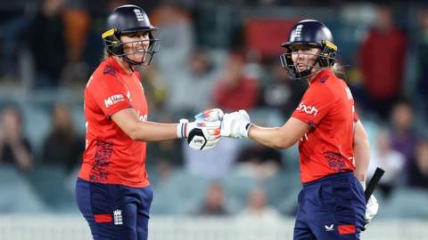 Nat Sciver-Brunt (left) and Heather Knight bump fists during the Women's Ashes T20 in Canberra