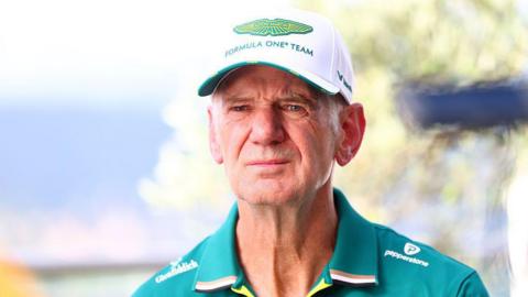 Adrian Newey wearing an Aston Martin cap and team kit 