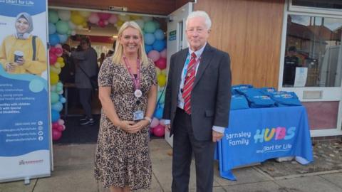 Councillor Trevor Cave standing outside the Penistone Family Hub, in front of tables, balloons and signs explaining what the centre is