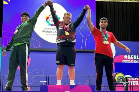 Bleddyn and fellow medallists hold their arms aloft after accepting their medals