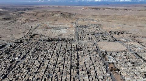 This aerial view shows the modern city of Palmyra in central Syria and the nearby ancient Palmyrene ruins on February 7, 2025.