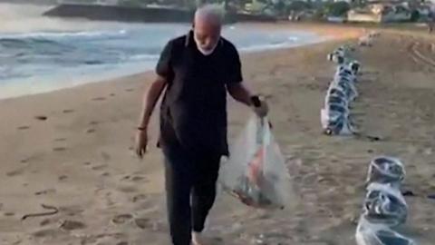 Prime Minister Narendra Modi cleans up a beach