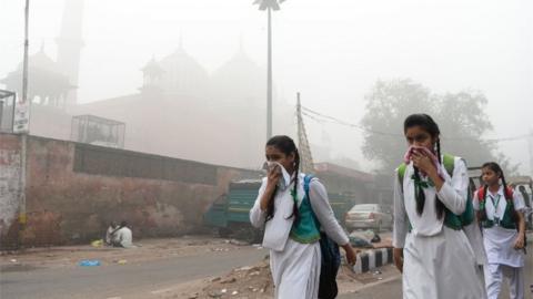 This file photo taken on November 8, 2017 shows Indian school girls covering their faces amid heavy smog of New Delhi.