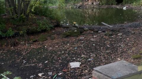 Dried-up mud bed next to receding waters of partly-dried up lake. 