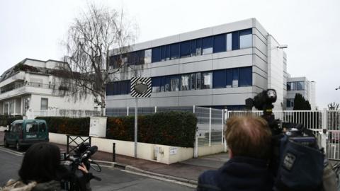 Cameramen film in front of the French far-right Front National (FN) headquarters in Nanterre, near Paris on 20 February 2017 during a search of the party's offices