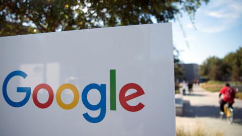 Man rides bike past sign outside Google, Menlo Park