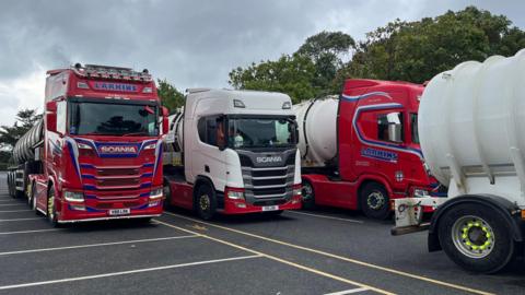 A queue of sewage trucks