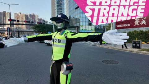 A traffic robot and the Strange logo