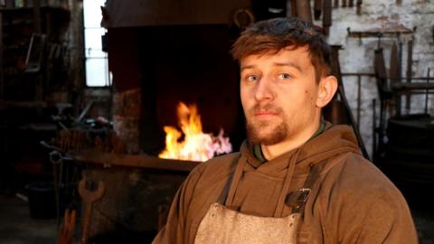 Jay Cardall with a flame behind him