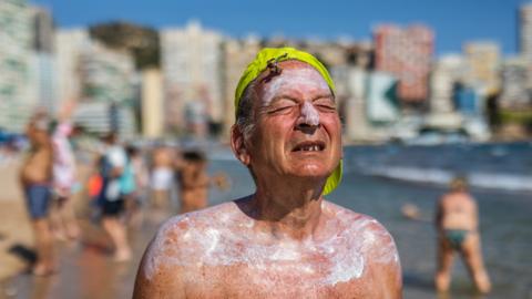 Man with suncream on the beach in Spain