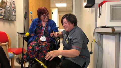 Caroline Coster with nurse Cathy O'Brien and her large tan and black dog Duke