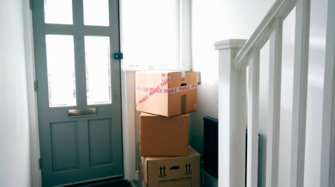 Moving brown boxes in hallway of home