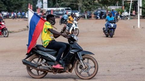 Motorbike rider carries Russian flag