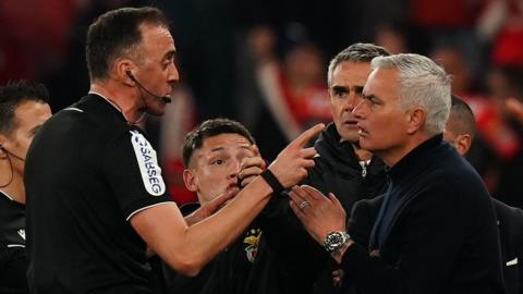 Referee Joao Pinheiro speaks with Head Coach Jose Mourinho of SL Benfica 