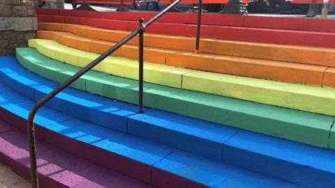 A set of stairs, each one painted a different colour of the rainbow