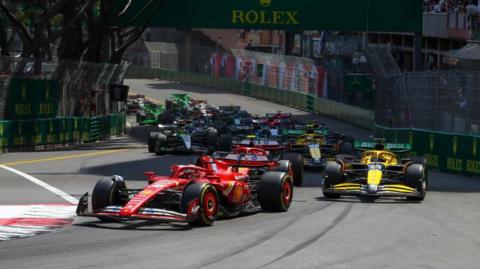 Charles Leclerc of Ferrari leads the field at the first corner of the 2024 Monaco Grand Prix