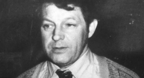 A black and white photo of a man in a suit 