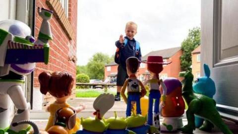 Vinny waving goodbye to his Toy Story collection on his first day of school 