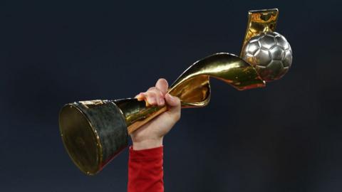 A player holding the World Cup trophy