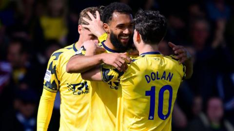 Torquay players celebrate a goal scored by Deon Moore