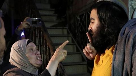 A Palestinian woman and an Israeli man argue ahead of an Israeli Supreme Court hearing about the case of Palestinian families facing eviction from their homes in the Sheikh Jarrah of occupied East Jerusalem (3 May 2021)