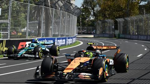 McLaren's Lando Norris passes Aston Martin's Fernando Alonso during first practice for the Australian Grand Prix